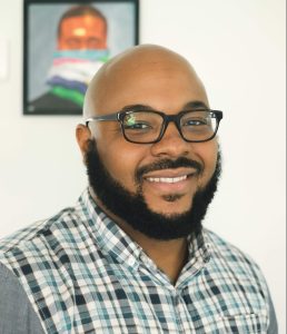 Headshot of poet Nate Marshall, a Black man with a beard and glasses and shaved head.